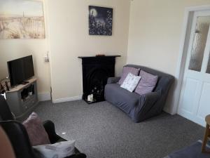 a living room with a couch and a television at Mountain View Cottage in Limavady