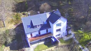 an aerial view of a large white house with a black roof at Ferienwohnung Schneeberg in Stryck