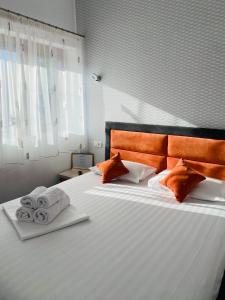 a bedroom with a large bed with towels on it at Orange House Constanta in Constanţa
