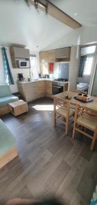 a kitchen with a table and a dining room at MH 150 camping 4 etoiles Bois Dormant 4 personnes in Saint-Jean-de-Monts