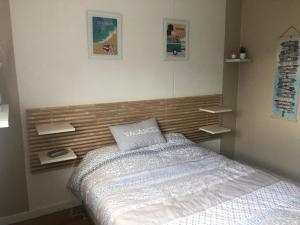 スーストンにあるVilla de vacances Vieux Boucauの木製のヘッドボードが付いたベッドのある寝室