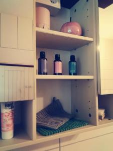 a shelf in a kitchen with bottles on it at FeWo Unner'd Kastanje in Moormerland
