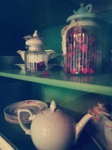 a shelf with dishes and tea pots on it at FeWo Unner'd Kastanje in Moormerland