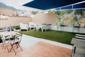 a patio with chairs and tables and a green lawn at Endless Summer House in Adeje