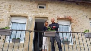 a man and a woman standing on a balcony at Le cottage du village in Seigny