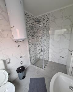 La salle de bains est pourvue d'une douche, de toilettes et d'un lavabo. dans l'établissement Apartmani Bugojno, à Bugojno