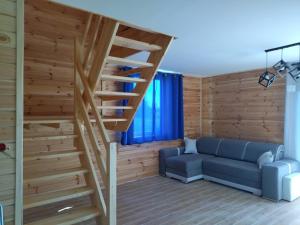 salon ze schodami i niebieską kanapą w obiekcie Domki Jastrzębia Mazury w Pasymiu