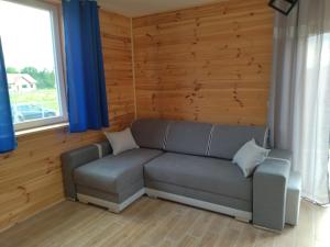 a living room with a couch and a window at Domki Jastrzębia Mazury in Pasym