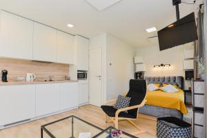 a small apartment with a bed and a kitchen at La Mer Palanga apartamentai su baseinu ir terasa in Palanga