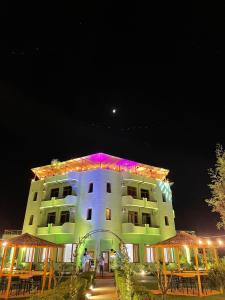 a large building with lights on it at night at PARADISE Laguna Vain in Lezhë