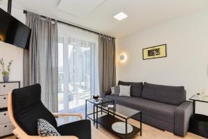 a living room with a couch and a window at La Mer Palanga apartamentai su baseinu ir terasa in Palanga