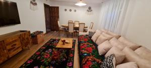 a living room with a couch and a table at Acul în carul cu fan in Pădurenii