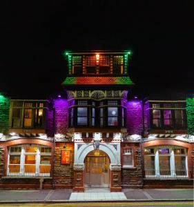 - un bâtiment avec des lumières violettes et vertes dans l'établissement Cwmcarn Hotel & Bunkhouse, à Cwmcarn