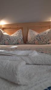 een bed met witte lakens en kussens erop bij Casa Camelia in Sovata