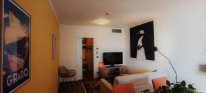 a living room with a white couch and a television at Hotel Antares in Grado