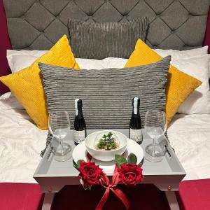 uma mesa com um prato de comida e duas garrafas de vinho em Spacious 1 bed relocation apartment free parking, em Brierley Hill