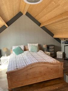 Cama grande en habitación con techo de madera en Tjotter en Ámsterdam