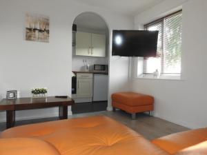 a living room with a television and a kitchen at Serviced Accommodation in Hull