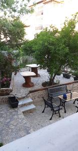 park z ławkami, stołem i drzewami w obiekcie Agapaki Studios w mieście Neos Marmaras
