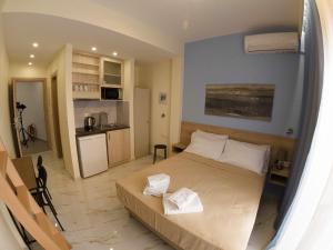 a bedroom with a large bed and a kitchen at Agapaki Studios in Neos Marmaras