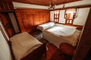 a small bedroom with two beds and a chair at Çamlıca Konak Çarsı in Safranbolu