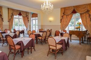 a restaurant with tables and chairs and a chandelier at The Grove Hotel in Bournemouth