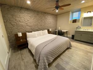 1 dormitorio con cama y pared de piedra en Hotel Ouray - for 12 years old and over en Ouray