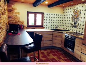 a kitchen with a sink and a table in it at Maison de la Sauer - Bed and Breakfast | Chambre d’hôtes | Ferienhaus in Munchhausen