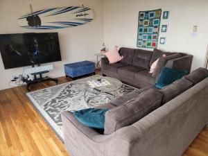 a living room with a couch and a table at BEACHFRONT COTTAGE UPPER UNIT in Oceanside