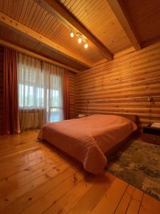 a bedroom with a bed in a wooden room at Hotel complex Lenivaya Vera in Novaki