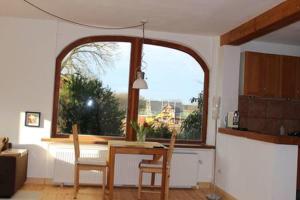 a kitchen with a table and a large window at Top Appartement 2 in Rosengarten/Hamburg in Rosengarten