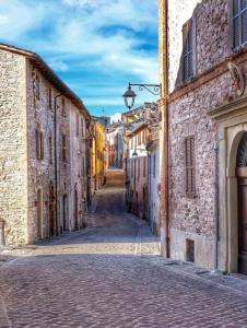 un callejón en un casco antiguo con edificios de piedra en Degli Alessandri tower, en Sassoferrato