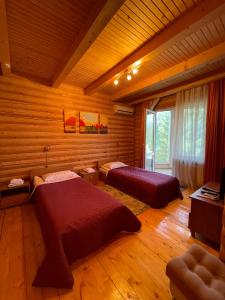 una camera con 2 letti in una baita di tronchi di Hotel complex Lenivaya Vera a Novaki