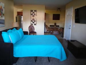 a bedroom with a blue bed and a living room at Departamento completo en San Diego hablamos español in San Diego