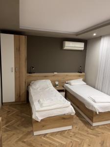 Ivet Guest rooms في مدينة فارنا: سريرين في غرفة ذات أرضيات خشبية