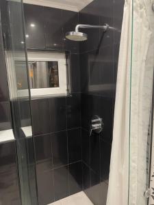 a bathroom with a glass shower with a window at Ivet Guest rooms in Varna City