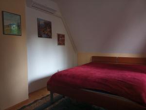 a bedroom with a bed with a red blanket at Cottage Forest Stream in Visoko