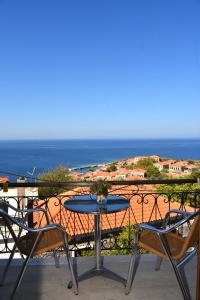 a table and chairs on a balcony with the ocean at Maria & Kiki 2 Studios in Mithymna +15 photos