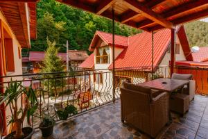 a patio with a table and chairs on a balcony at Pensiunea LUKA Slanic Moldova in Slănic-Moldova