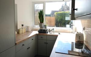 cocina con fregadero y ventana en Regency cottage 10 minutes from Bath city centre, en Bath