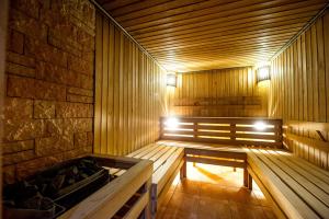 a wooden sauna with a bench and lights in it at Goldman Empire in Astana