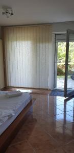 a bedroom with a bed and a sliding glass door at Apartman No 1 in Sretenovo