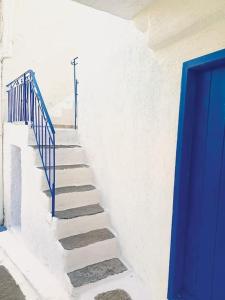 un escalier avec une porte bleue et une rampe bleue dans l'établissement Στη Μεσσάδα... Sti Messada..., à Ioulída