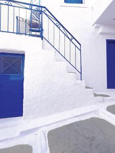 a stairway with a blue door and a stair railing at Στη Μεσσάδα... Sti Messada... in Ioulida
