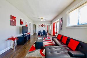a living room with a couch and a television at The Rubi Lounge - Spacious Brooklyn Centre Modern Escape Near Downtown With Parking, 300MB WiFi & Self Check-In in Cleveland