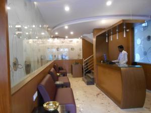 a man standing at a counter in a restaurant at Hotel Aditya in Mysore