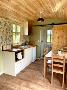 a kitchen with a wooden ceiling and a wooden table at Stepping Stones Glamping ‘the olive’ in Bantry