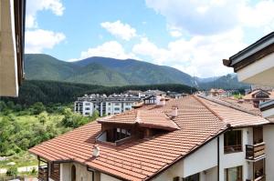 een uitzicht op een gebouw met een rood dak bij Двустаен апартамент Горски кът Банско in Bansko