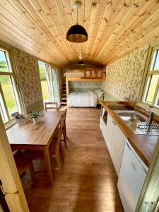 a kitchen and dining room with a table and a bed at Stepping Stones Glamping ‘the olive’ in Bantry