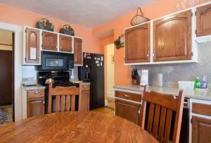 a kitchen with wooden cabinets and a wooden table in a room at Victorian Condo in Boston